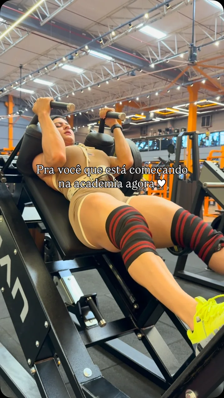 Vallery no aparelho de treino de pernas, com a frase Pra você que está começando na academia agora